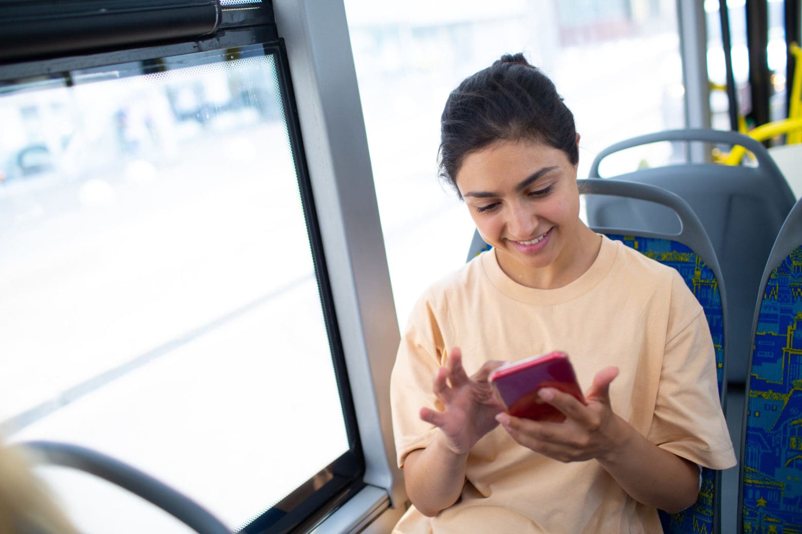 Woman on public transport bus using phone